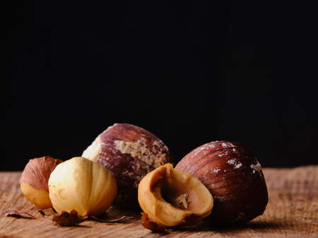 Raw hazelnuts on wood table with dark backgroundの写真素材