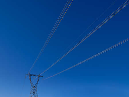 wire perspective electric tower on blue skyの写真素材