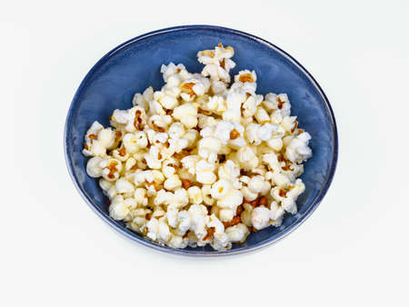 popcorn on blue bowl isolated on white backgroundの写真素材