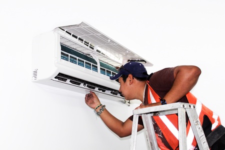 Young repairman fixing a ductless minisplit air conditioning system. Real situationの写真素材