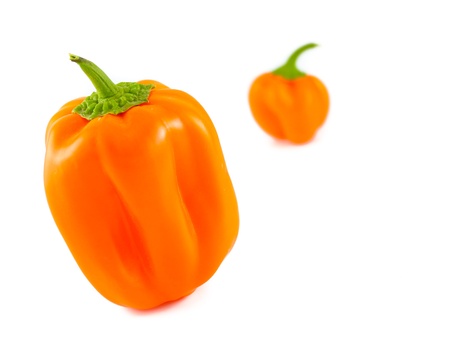 Fresh orange bell peppers. Focus on the front pepper.