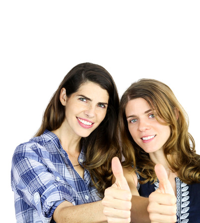 two beautiful young women showing thumbs upの写真素材