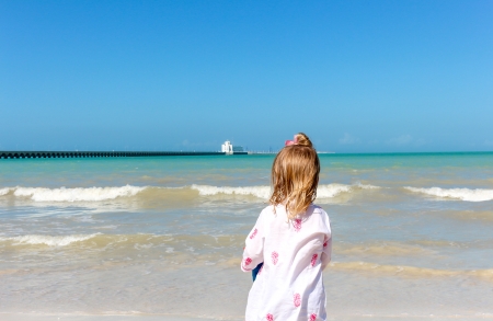 one Little girl staring at the ocean on a Yucatan beachの写真素材