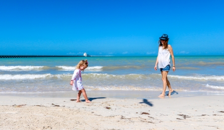 Mom and child playing on a Yucatan peninsula beachの写真素材