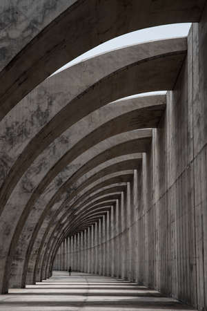 concrete structure in the shape of arches and the silhouette of a personの写真素材