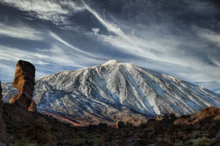 a snowy mountain and the sky with white clouds and blue tonesの写真素材