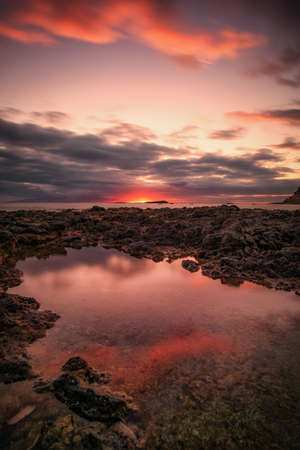 landscape of a sandy beach in a sunset and with reflections in the water