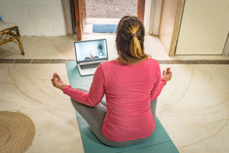 a caucasian woman practices crying at home online with her laptopの写真素材