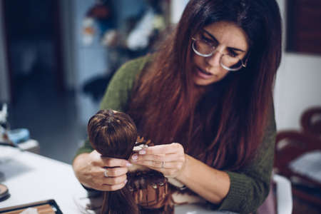 Long-haired young woman makes a rag dollの写真素材