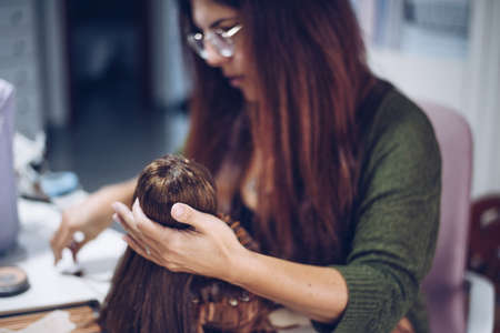 Long-haired young woman makes a rag dollの写真素材