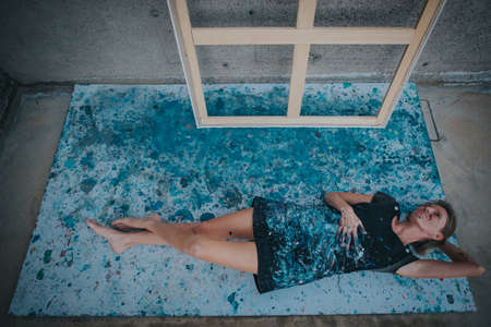 you can see a young female painter resting on a paper covered by paintの写真素材