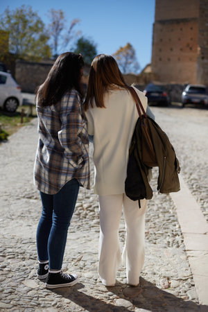 Back view of anonymous girls looking at their cell phones on a sunny dayの写真素材