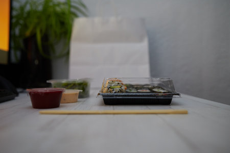 Side view of assorted sushi and rolls with soy sauce placed on wooden tableの写真素材
