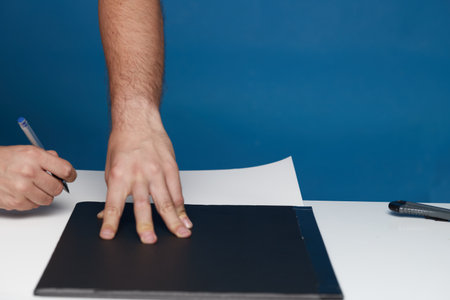 Anonymous person marking with a ballpoint pen on a cardboard card