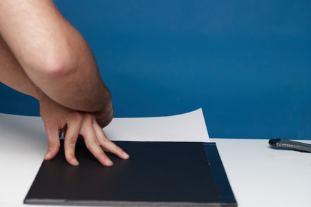 Anonymous person marking with a ballpoint pen on a cardboard cardの写真素材