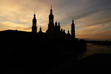 Silhouette of the basilica del pilar in a sunset next to the ebro riverの写真素材