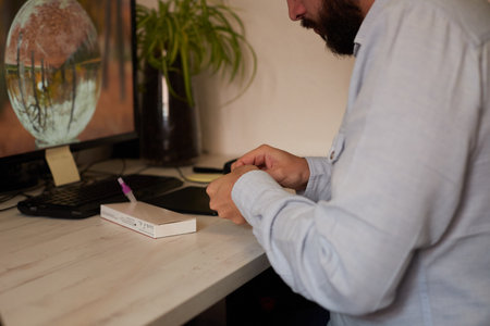 Anonymous teleworker taking out material for a rapid coronavirus testの写真素材