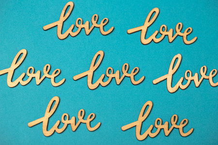 Top view composition of wooden Love signs placed in staggered rows on blue surfaceの写真素材