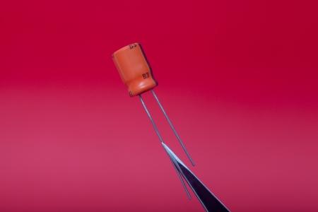 Detail of capacitor in red background