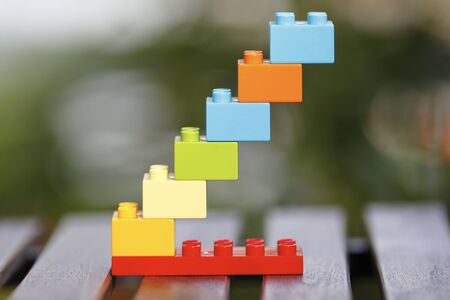 Toy block stairs leading to success with unfocused background.