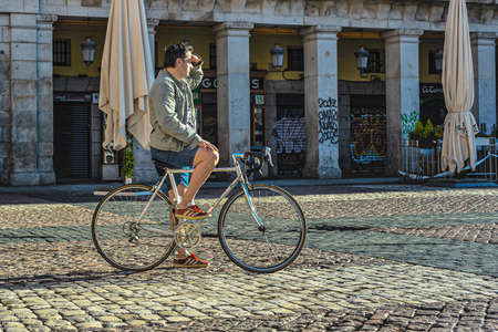 Madrid, Spain, 22 May 2020: During the quarantine in the city a man stops his bike ride to see the sunrise. in the Plaza Mayor.のeditorial素材