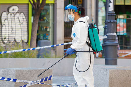 Madrid, Spain, 22 may 2020: Working woman disinfecting the streets with special equipment to combat the coronavirus.のeditorial素材