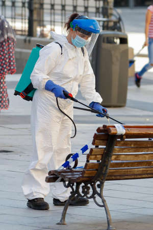 Madrid, Spain, May 22, 2020: working women disinfecting the street seats with special equipment to combat the coronavirus.のeditorial素材