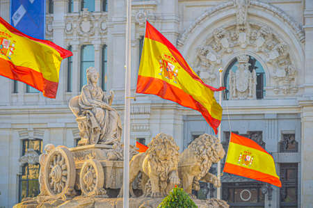 MADRID, SPAIN - 26 May 2020: Spain Declares 10-Day Official Mourning for Coronavirus Victims. Flags are flown at half-mast at Cibeles statue in Madrid central.のeditorial素材