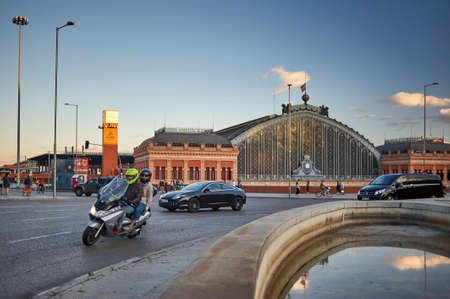 Madrid, Spain - June 4, 2020: Road traffic in the square with the Atocha train station in the background at sunset.のeditorial素材