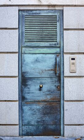 Green metallic door closed with an intercom
