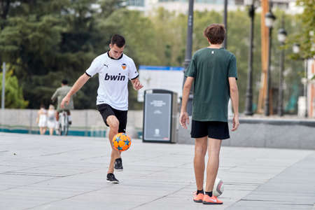 Madrid, Spain - August 8, 2020: Young people practice European football on the street