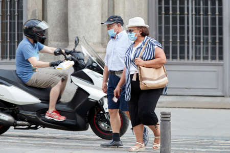 Madrid, Spain - August 8, 2020: Tourists and walkers walk through the city of in a sunset in the city of Madrid. People wear a mask to protect yourself from Covid-19のeditorial素材