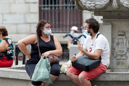 Madrid, Spain - August 8, 2020: Tourists and walkers walk through the city of in a sunset in the city of Madrid. People wear a mask to protect yourself from Covid-19のeditorial素材