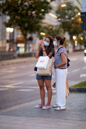 Madrid, Spain - August 8, 2020: Tourists and walkers walk through the city of in a sunset in the city of Madrid. People wear a mask to protect yourself from Covid-19のeditorial素材