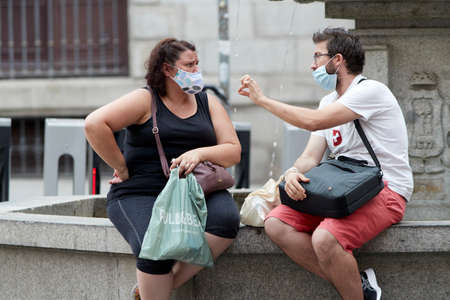 Madrid, Spain - August 8, 2020: Tourists and walkers walk through the city of in a sunset in the city of Madrid. People wear a mask to protect yourself from Covid-19のeditorial素材