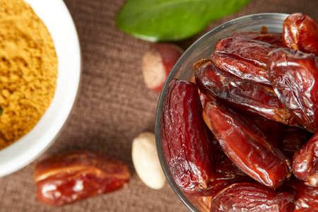 Various raw nuts: hazelnuts, pistachios, chestnuts, dates and oranges.