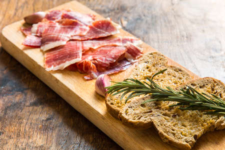 Spanish ham with toasts,rosemay,garlic and olive oilの写真素材