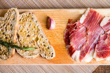 Spanish iberico ham with toasts on wood tableの写真素材