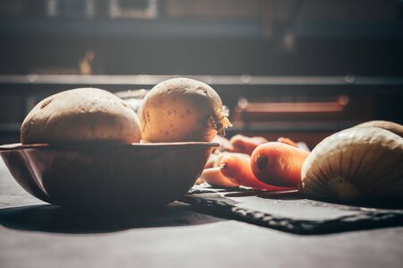 Different vegetables on a black table with midday soft sun light.Copy space. Concept of food and healthの写真素材