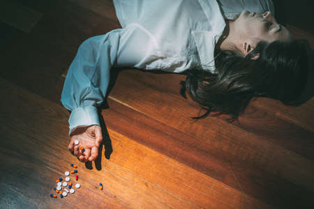 Woman lay down after taking medicine overdose.Copy space.Concept of death and drugs overdoseの写真素材