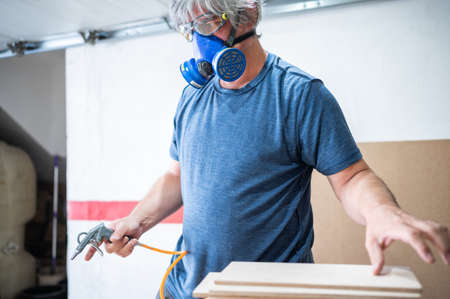 Man with dust mask working in his workshop.の写真素材