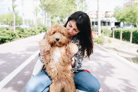 Caucasian woman looking happily at her little dog. Copy space. Love for animal concept.の写真素材