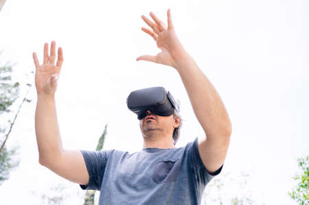 Male wearing virtual reality goggles on the street.Technology concept