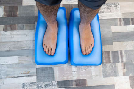 Man's feet on a pressure platform to make orthotics for the shoes