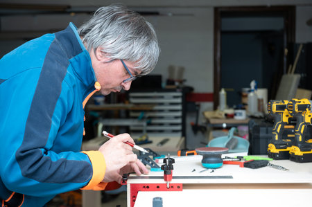 An experienced carpenter working with wood in his small workshop.Small business concept