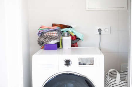 New washing machine clean with detergents, soaps and cleaning utensils on top. Clean house