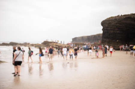 Blurred people walking along an overcrowded beach on summer. Overcrowded tourism conceptの写真素材