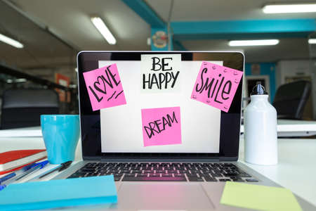 Colorful post it with words of enthusiasm on the computer screen on the office desktop. Relationship of colleagues conceptの写真素材