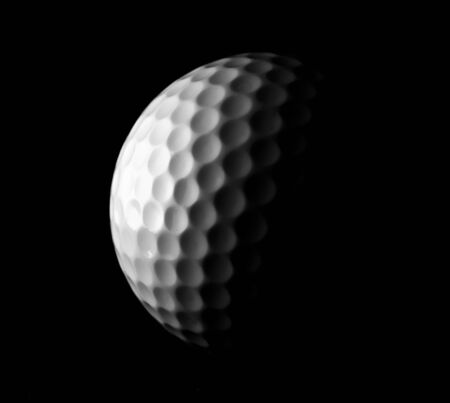 A golf ball as a descending moon in black and whiteの写真素材