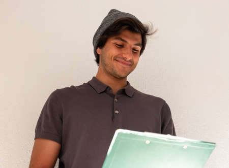 side view of high school or college student studying and writing in a notebook on a desk with a...